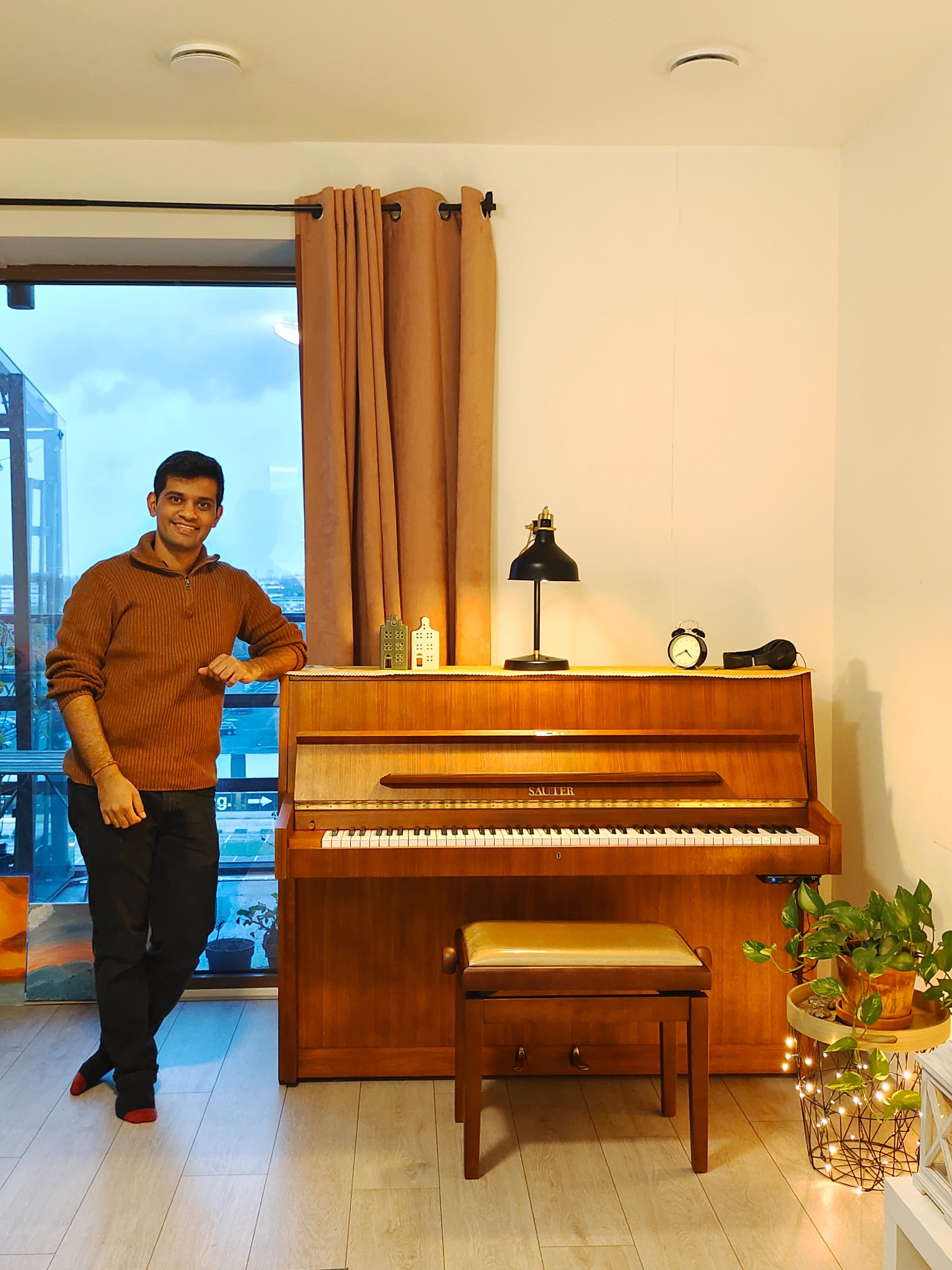 Ketan Jain standing beside his upright piano